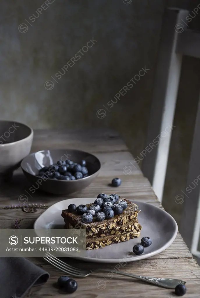 Breakfast with cereal bread and blueberries on wooden table