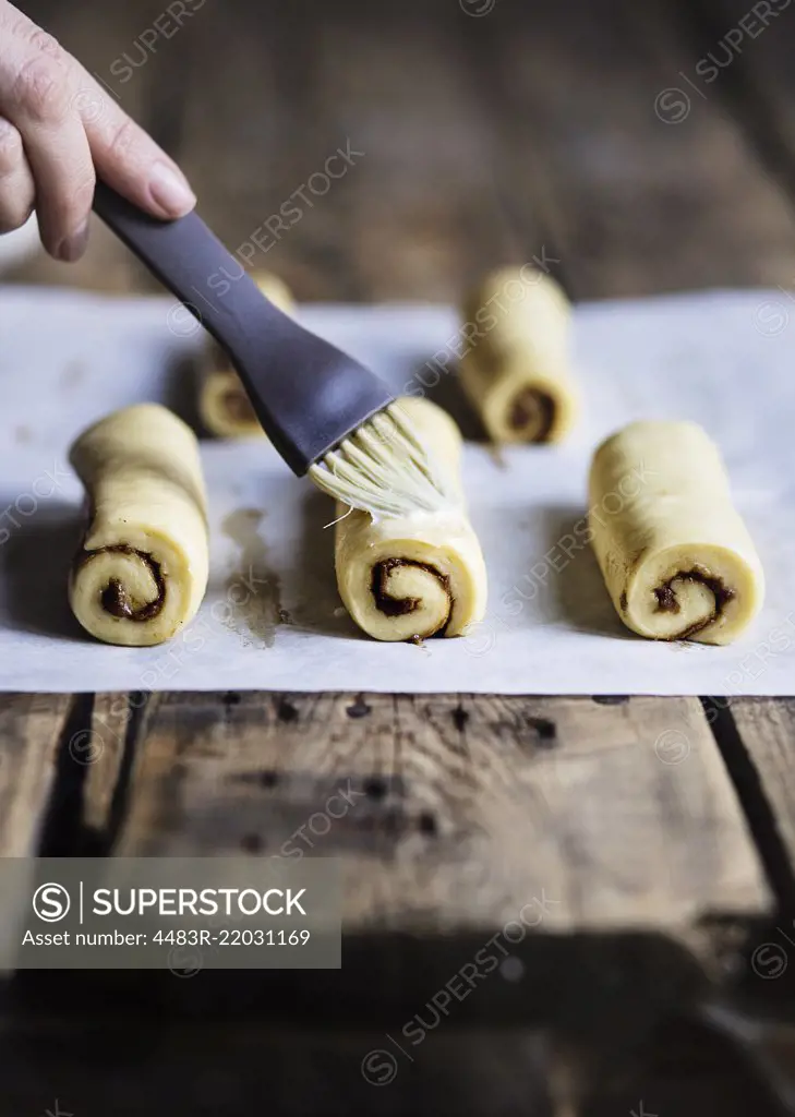 Raw cinnamon buns on wooden table before baking