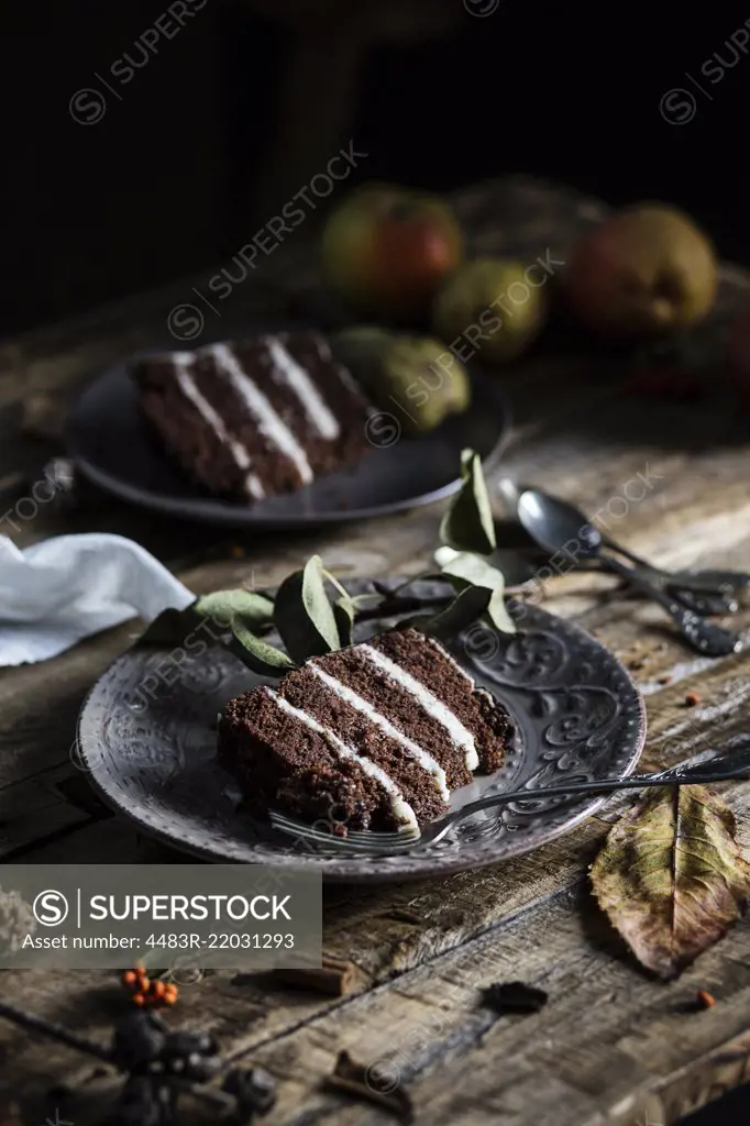 Autumn mood: slices of chocolate & pear cake on wooden table