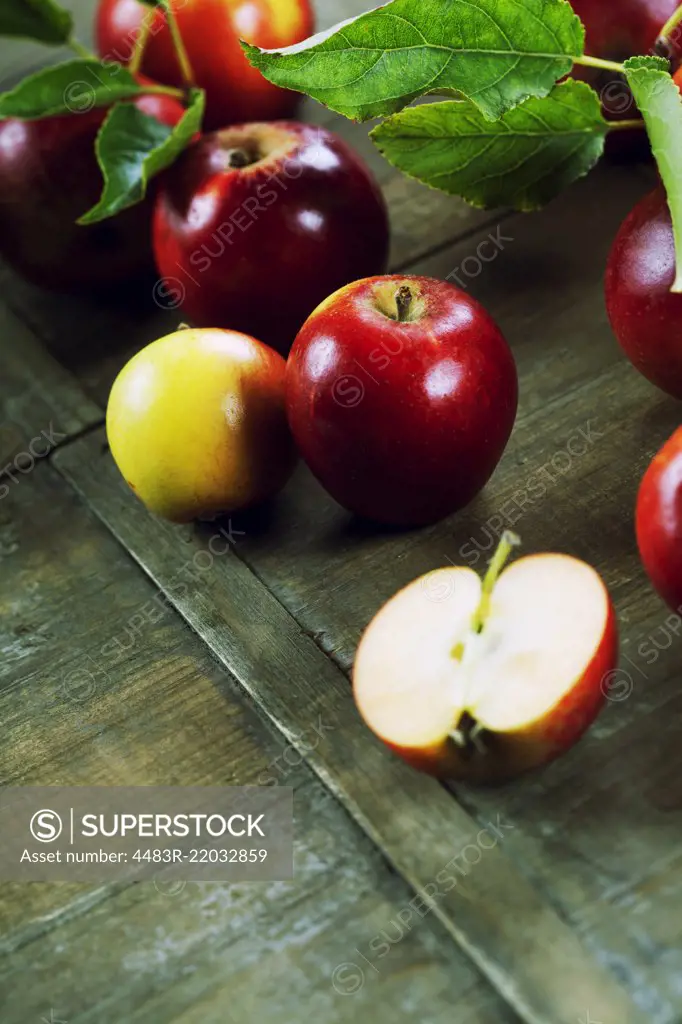 red apples with leaves on wooden table