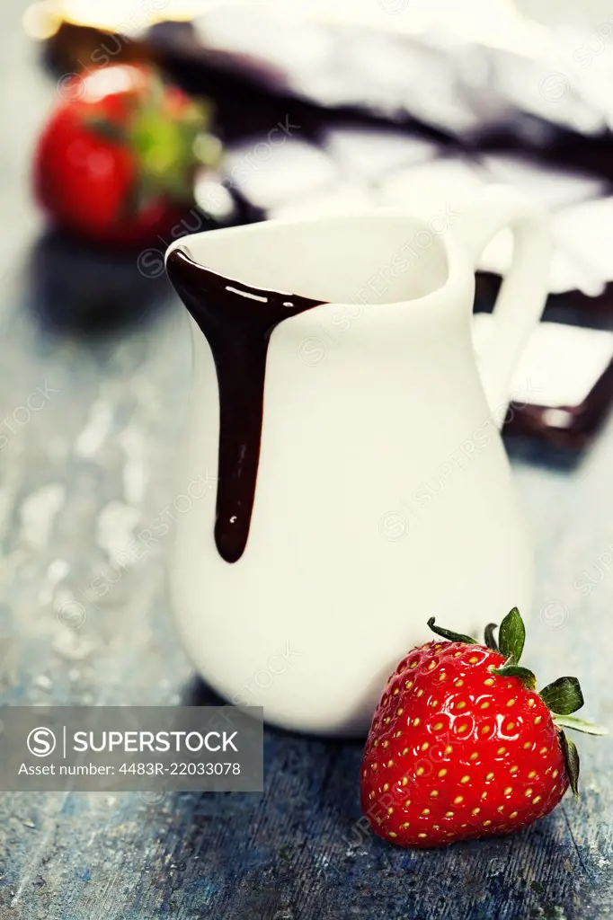 Delicious rich and thick chocolate sauce in a jug and assorted chocolates - food and drink