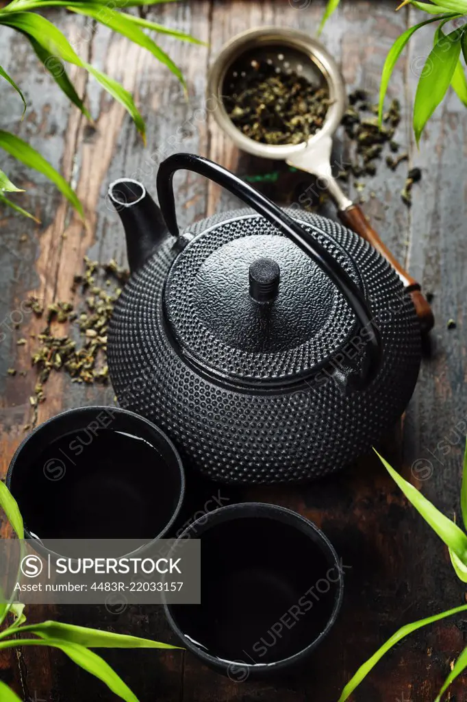 Image of traditional eastern teapot and teacups on wooden desk