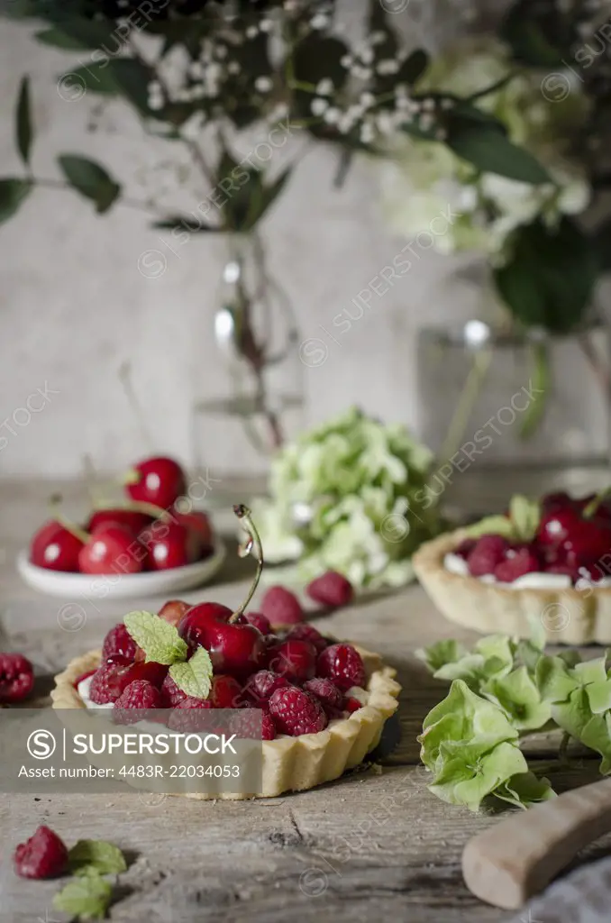 A cherry and raspberry tart on a kitchen table.