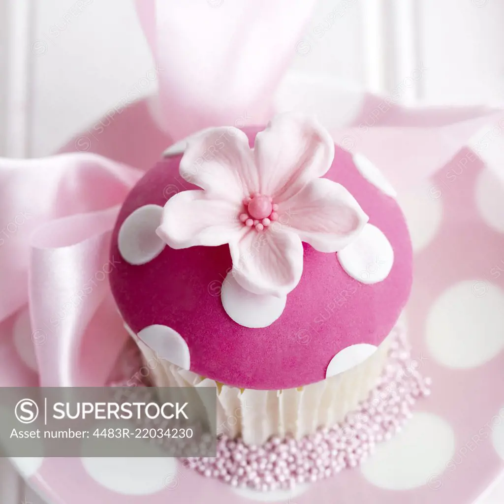 Cupcake decorated with a pink fondant flower