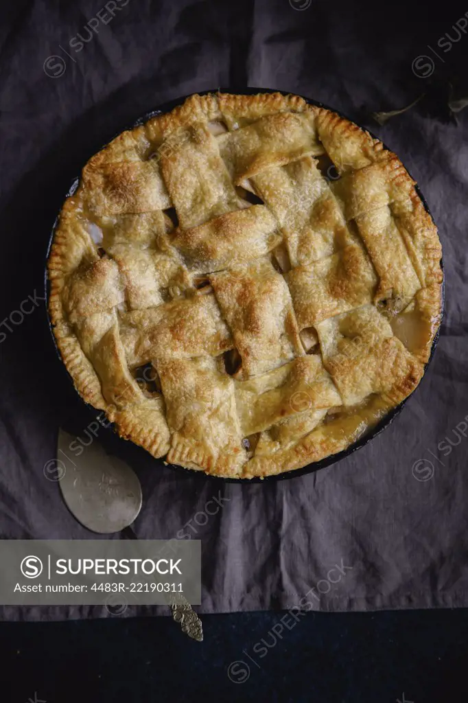 Apple pie with lattice decoration on dark background