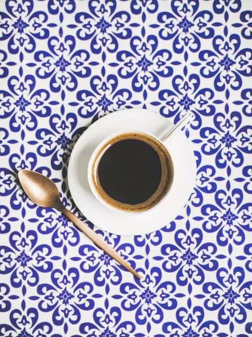 Cup of black Turkish or Eastern style coffee over oriental Moroccan patterned background, top view