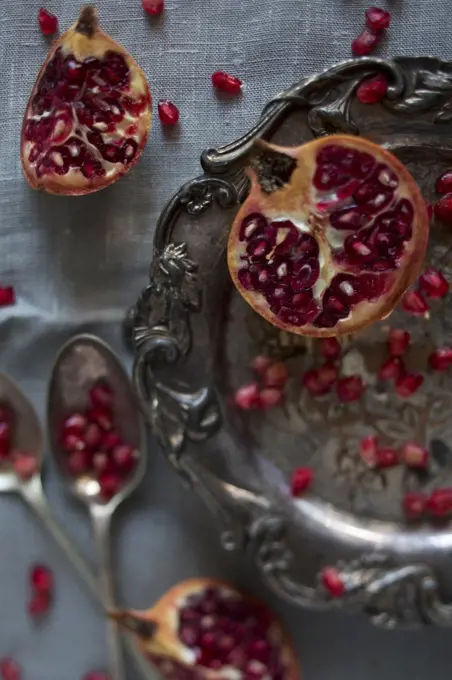 Pomegranate segments and seeds on a silver platter