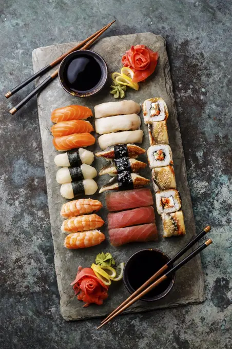 Sushi Set nigiri and sushi rolls served for two on gray stone slate on metal background