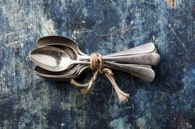 Bunch of silverware teaspoons on blue background