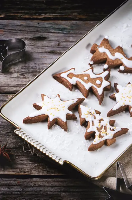 Plate with christmas cookies on old wooden table.