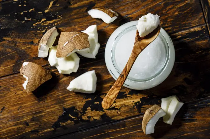 Organic healthy Coconut butter and fresh coconut pieces on wooden background