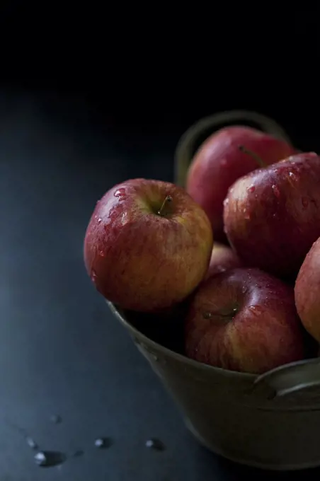 Fresh red apples in a bowl on a dark background