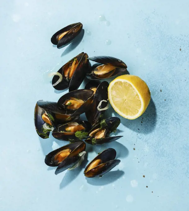 Mussels and lemon on blue background