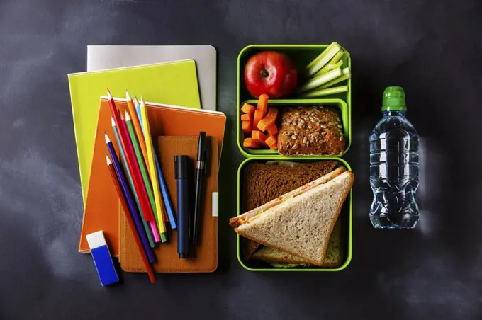 Take out food Lunch box with Sandwiches and vegetables, bottle of water and school supplies