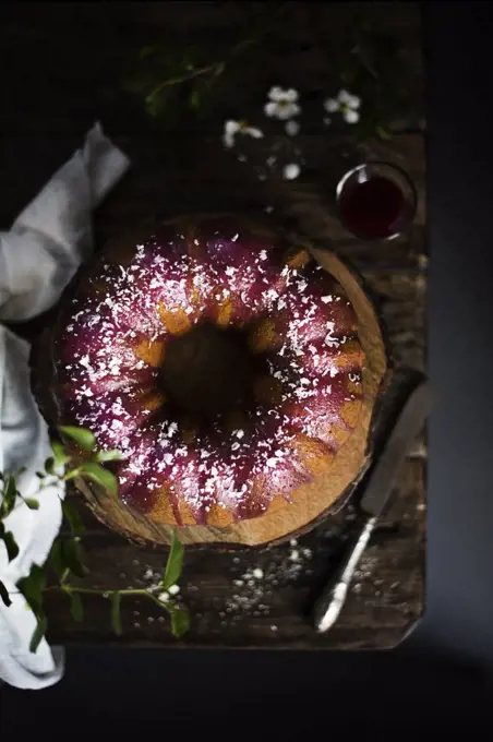 Bundt cake with blackberry glaze and white chocolate flakes