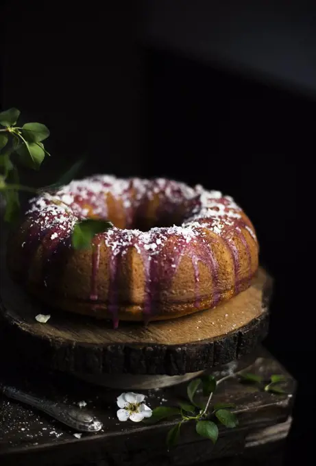 Bundt cake with blackberry glaze and white chocolate flakes