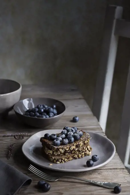 Breakfast with cereal bread and blueberries on wooden table