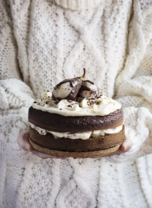 Woman's hands holding a chocolate cake