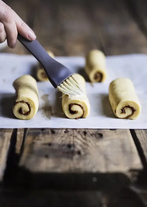 Raw cinnamon buns on wooden table before baking