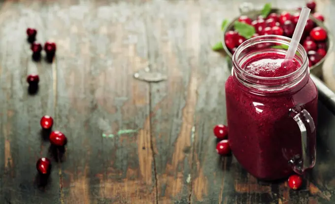 Cranberry smoothie on rustic wooden background - Healthy eating, Detox or Diet concept