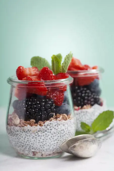 Chia seeds vanilla pudding and berries on blue background - Healthy food, Diet, Detox, Clean Eating or Vegetarian concept.