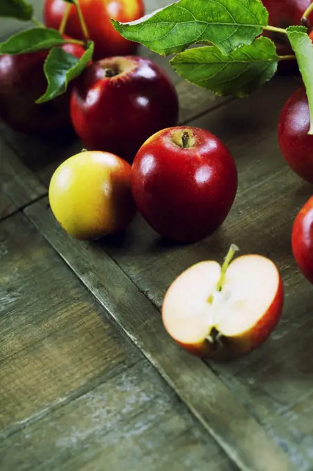 red apples with leaves on wooden table