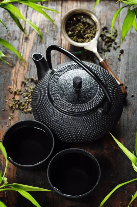 Image of traditional eastern teapot and teacups on wooden desk