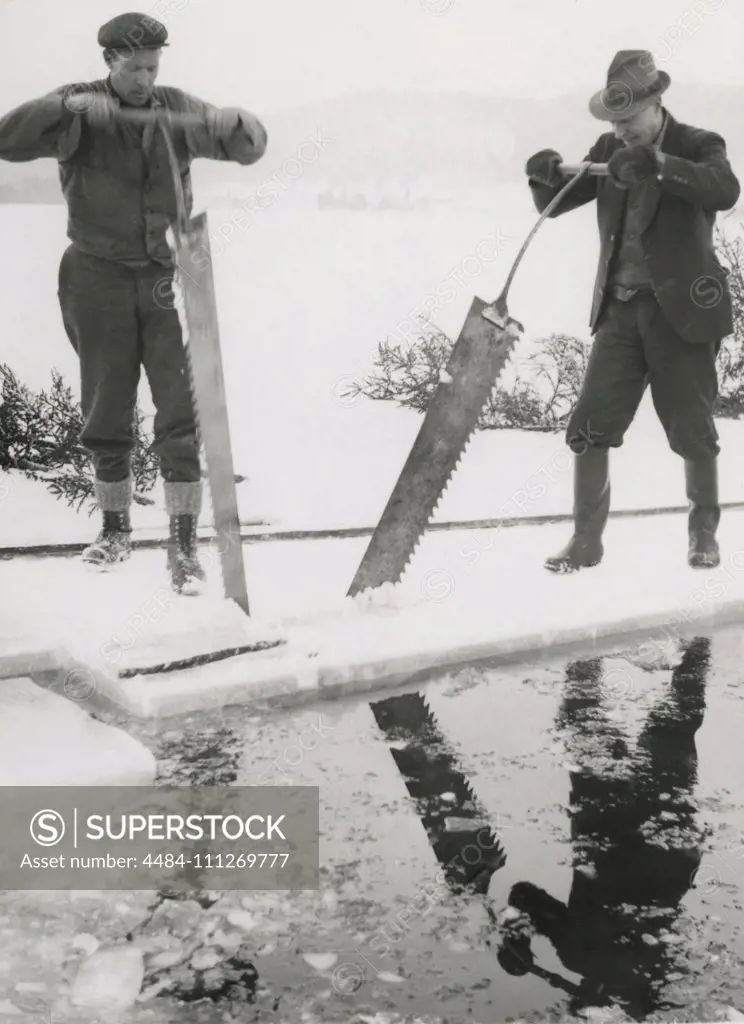 Workers collecting ice. Two men are sawing blocks of ice to  use in homes to keep groceries cool. Sweden 1940s