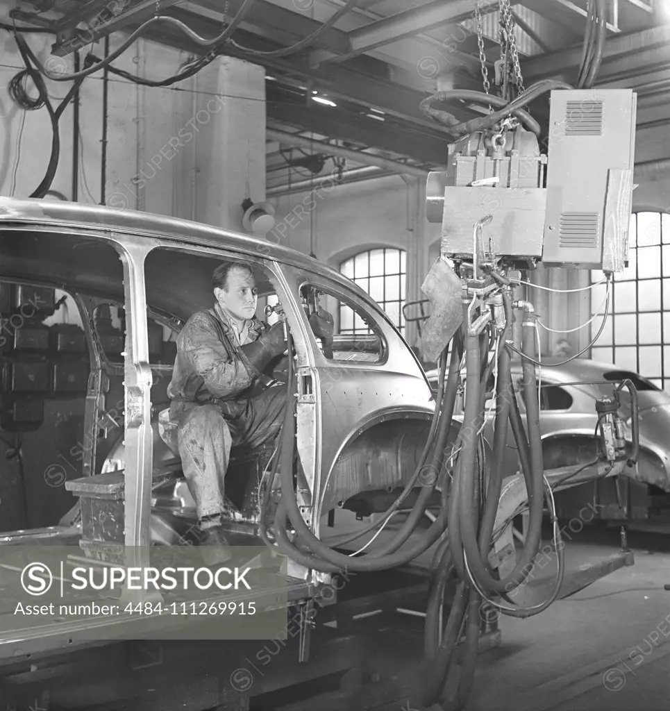 Car manufacturing in the 1940s. A worker in a car assembly line use an hydraulic tool to mount parts of the car together. After World war II several companies in Sweden recieved cars in parts and assembeled them. It was less cost to import car parts then the whole car. Sweden 1948. Kristoffersson ref AP89-4