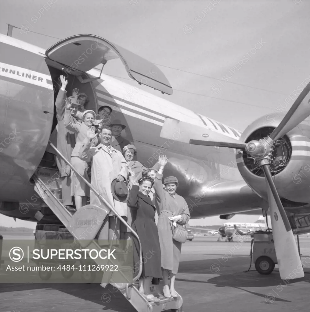 1950s vacation. A group of elderly people are standing on the stairs to an aircraft waving goodbye. Bromma airport Stockholm 1958. ref 3752