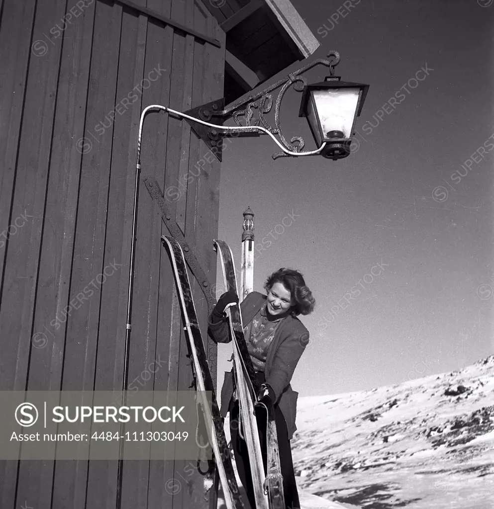 Winter in the 1940s. A young woman is preparing her skis and uses a seal skin underneath the skis to be able to climb the snowy mountain tops and not slide backwards. Sweden 1943. Kristoffersson Ref D70-4