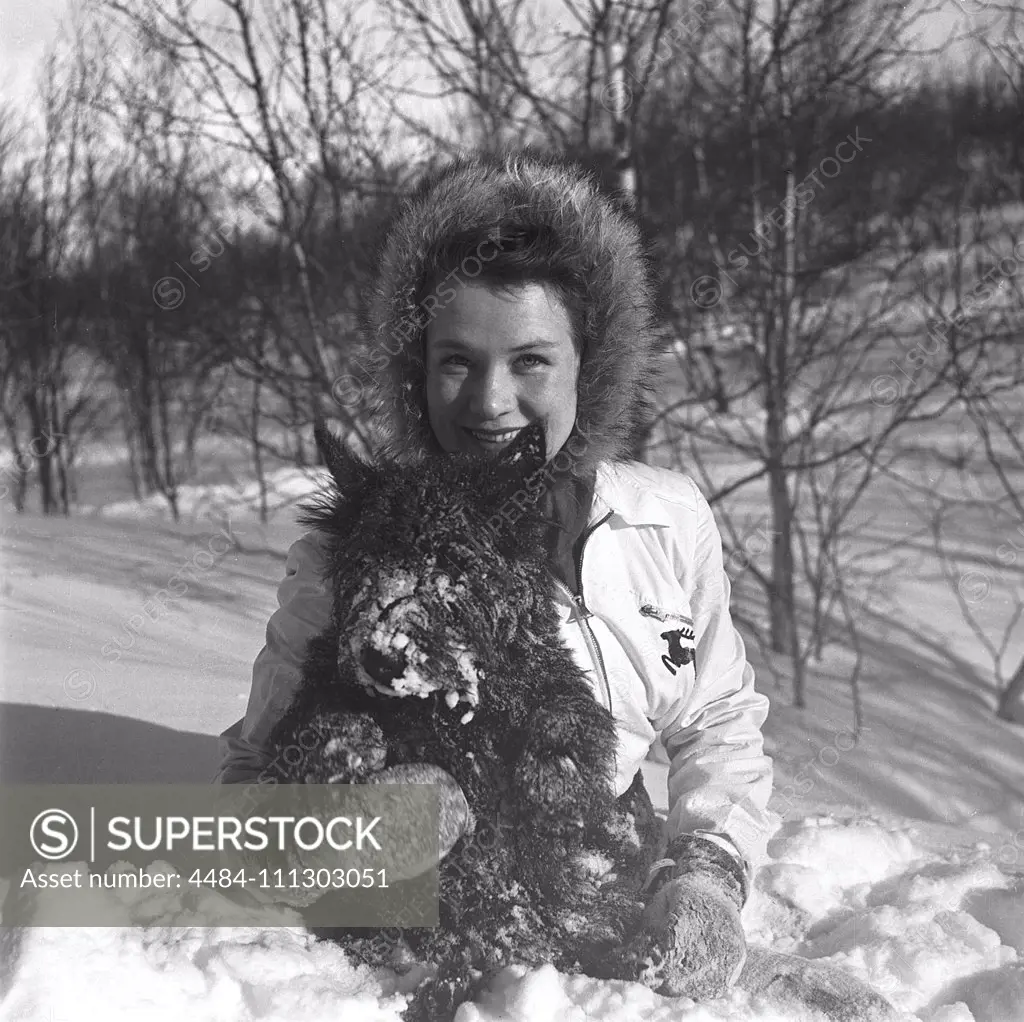 Winter in the 1940s. A young woman in the snow with her dog. Sweden 1943. Kristoffersson Ref D71-2