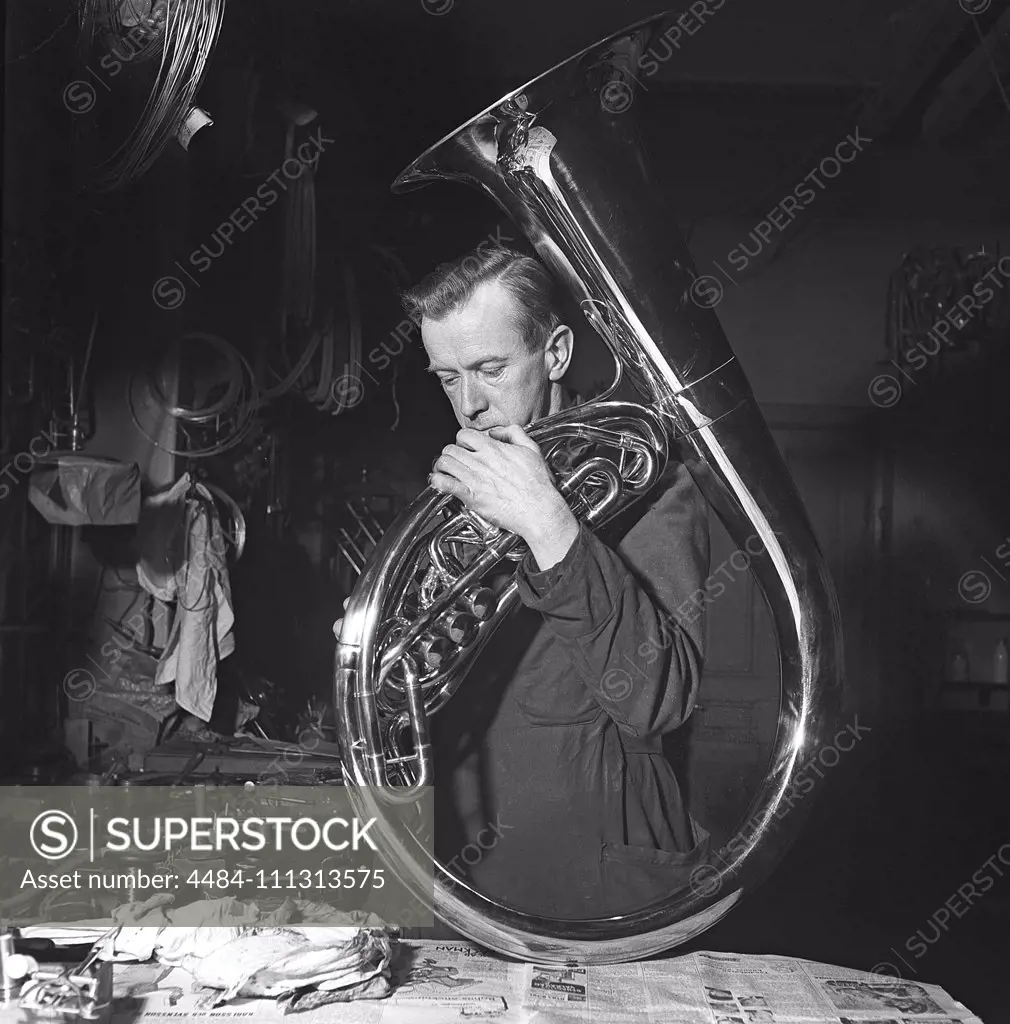 Workers in the 1940s. Interior of a mechanical workshop for musical instruments,  where a man is doing the last finishing touches to a tuba. Sweden 1941 Kristoffersson ref 225-1