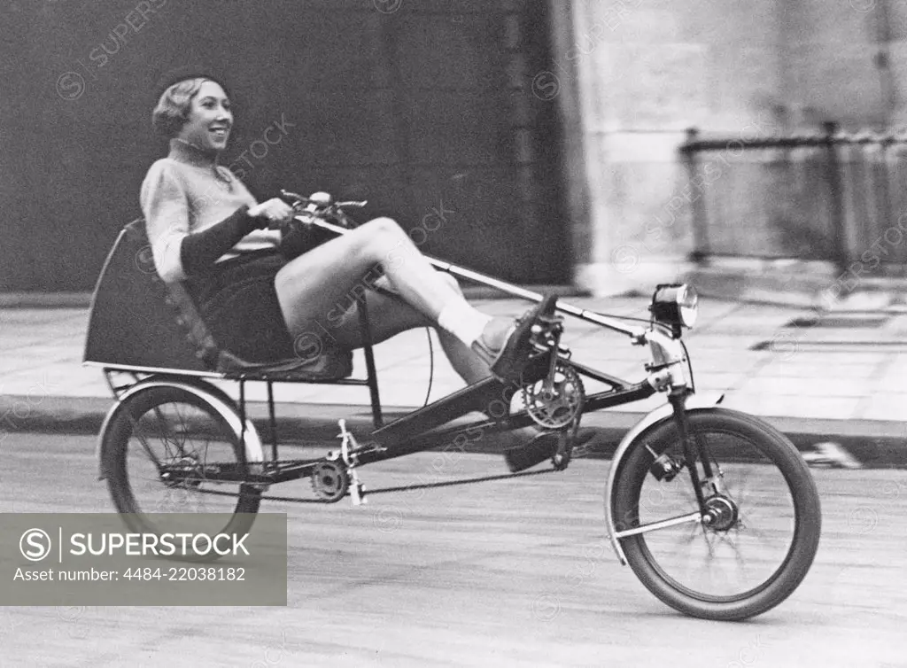 The Velocar 1933. The new horizontal bicycle is launched ath the Light Cycle Exhibition held at the Horticultural Hall at Westminster. Instead of sitting upright, the rides sits in an armchair position and pushes forwards with the legs. Pictures here Mrs. Evelyn Hamilton, champion cyclist,trying out the new Velocar bicycle. November 15 1933 More info on Evelyn Hamilton: http://classicpicturelibrary.blogspot.com/2018/08/record-breaking-woman-cyclist.html