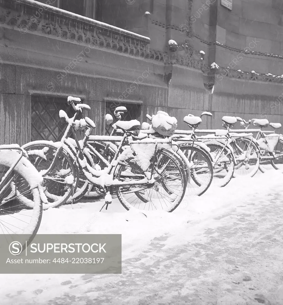 1940s bicycles. Bicycles are parked along the sidewalk on a snowy winters day. Sweden 1940s. Photo Kristoffersson AY59-5