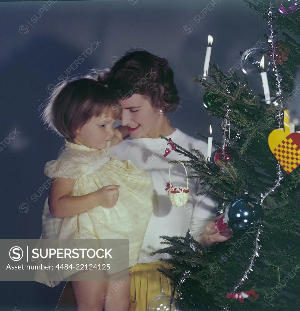 Christmas in the 1950s. A mother and her daughter is standing by the christmas tree. Sweden 1950s. Ref BV100-11