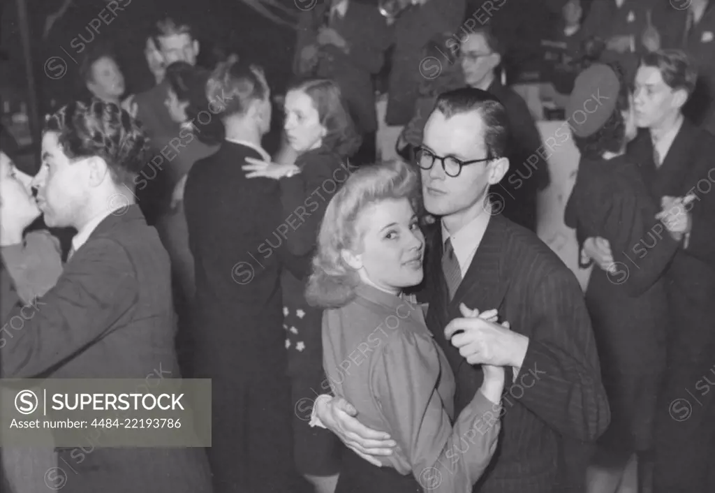 Dancing in the 1940s. The dance floor is filled with well dressed dancing couples, moving to the music at a party. Sweden 1946