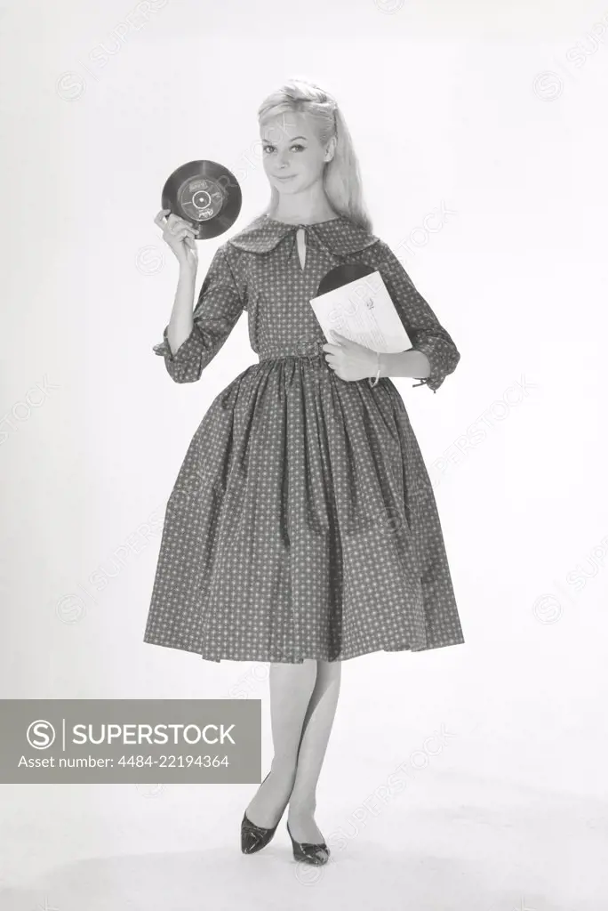 1950s fashion. A young woman in a typical 1950s dress. A wide skirt dress with a 50s patterened fabric. Sweden 1950s. Photo Kristoffersson ref CO93-4