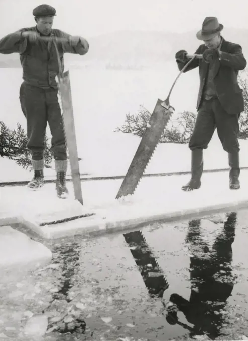 Workers collecting ice. Two men are sawing blocks of ice to  use in homes to keep groceries cool. Sweden 1940s