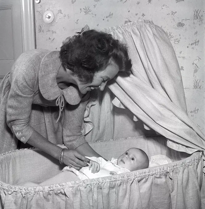 Motherhood in the 1950s. A mother is cuddling with her baby at home.  Sweden 1955. Kristoffersson ref BT40-4