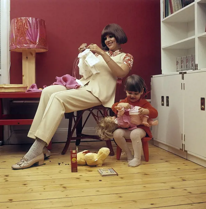 1960s mother. A young woman with her daughter are playing together with her doll. Sweden 1964