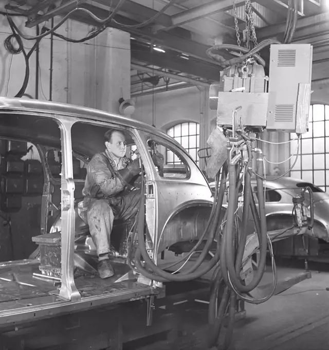 Car manufacturing in the 1940s. A worker in a car assembly line use an hydraulic tool to mount parts of the car together. After World war II several companies in Sweden recieved cars in parts and assembeled them. It was less cost to import car parts then the whole car. Sweden 1948. Kristoffersson ref AP89-4