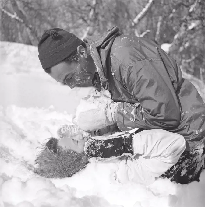 Winter in the 1940s. Actor Nils Kihlberg, 1915-1965 is pictured here with his wife Ann-Britt. They are both wearing winter clothes and plays in the snow laughing. Sweden 1943. Kristoffersson Ref D71-3