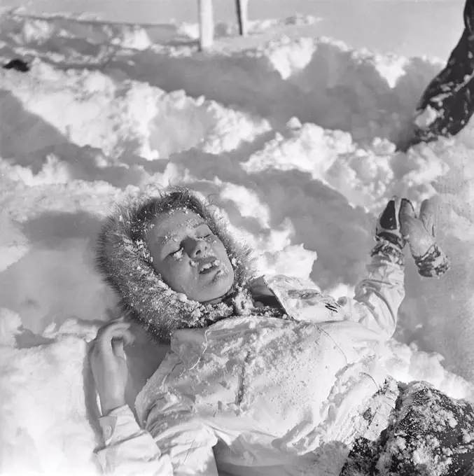 Winter in the 1940s. A young woman is lying in the snow. Sweden 1943. Kristoffersson Ref D70-3