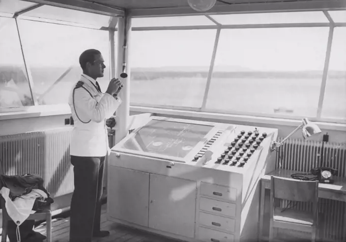 Air traffic controller in the 1940s. An officer in the airport control tower is monitoring the runway with binoculars.