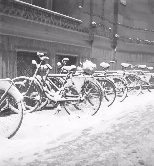 1940s bicycles. Bicycles are parked along the sidewalk on a snowy winters day. Sweden 1940s. Photo Kristoffersson AY59-5