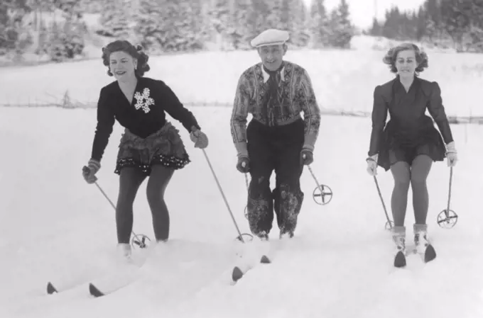 Skiing in the 1940s. The three individual skiing champions Britta Råhlén, Sven Selånger and Britta Lindmark are skiing through the snow. Sweden 1945