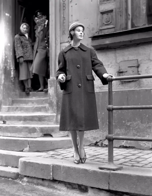 Fashionable in the 1950s. A young woman wears a typical 1950s coat. She poses in the outfit in a street. Sweden 1950s. Photo Kristoffersson Ref 314A-4