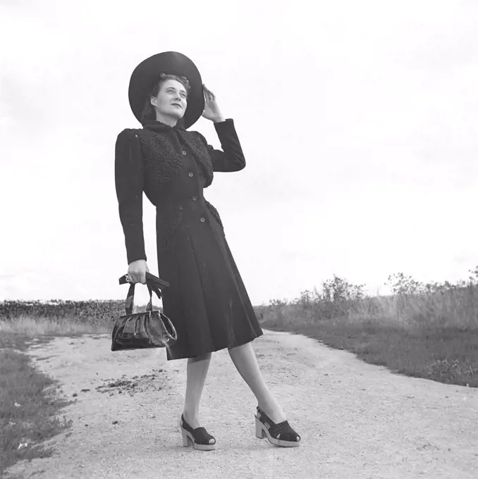 Women's fashion in the 1940s. A young woman in a typical 1940s coat with matching hat, shoes, gloves and handbag. Photo Kristoffersson Ref V77-6. Sweden 1947