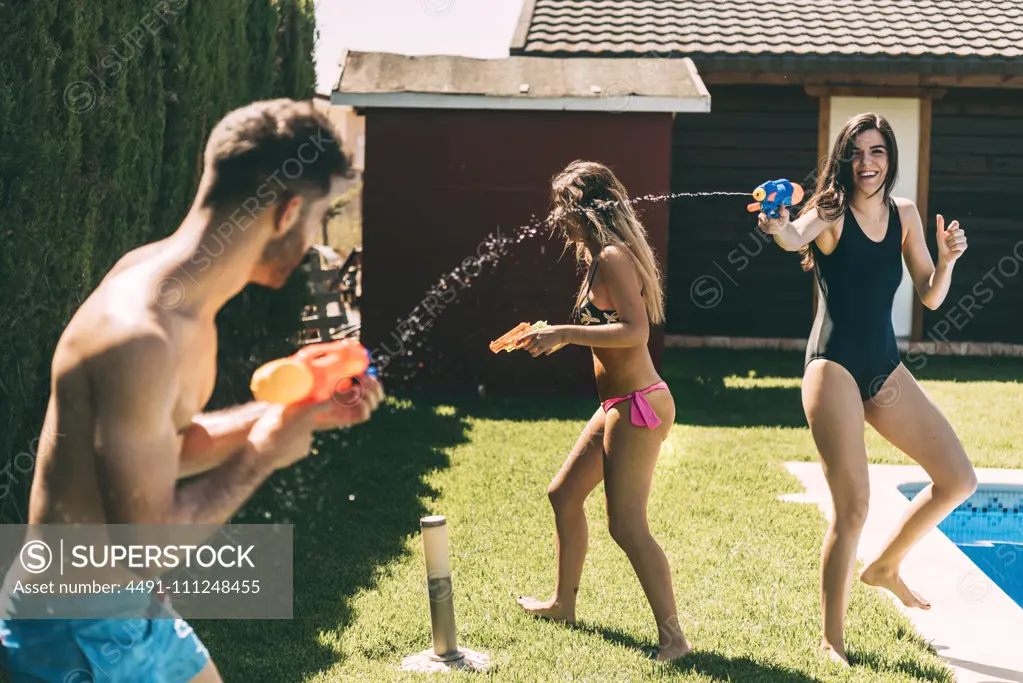 Friends splashing with water guns